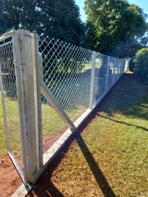 Tela de alambrado com mourões de concreto fechando terreno